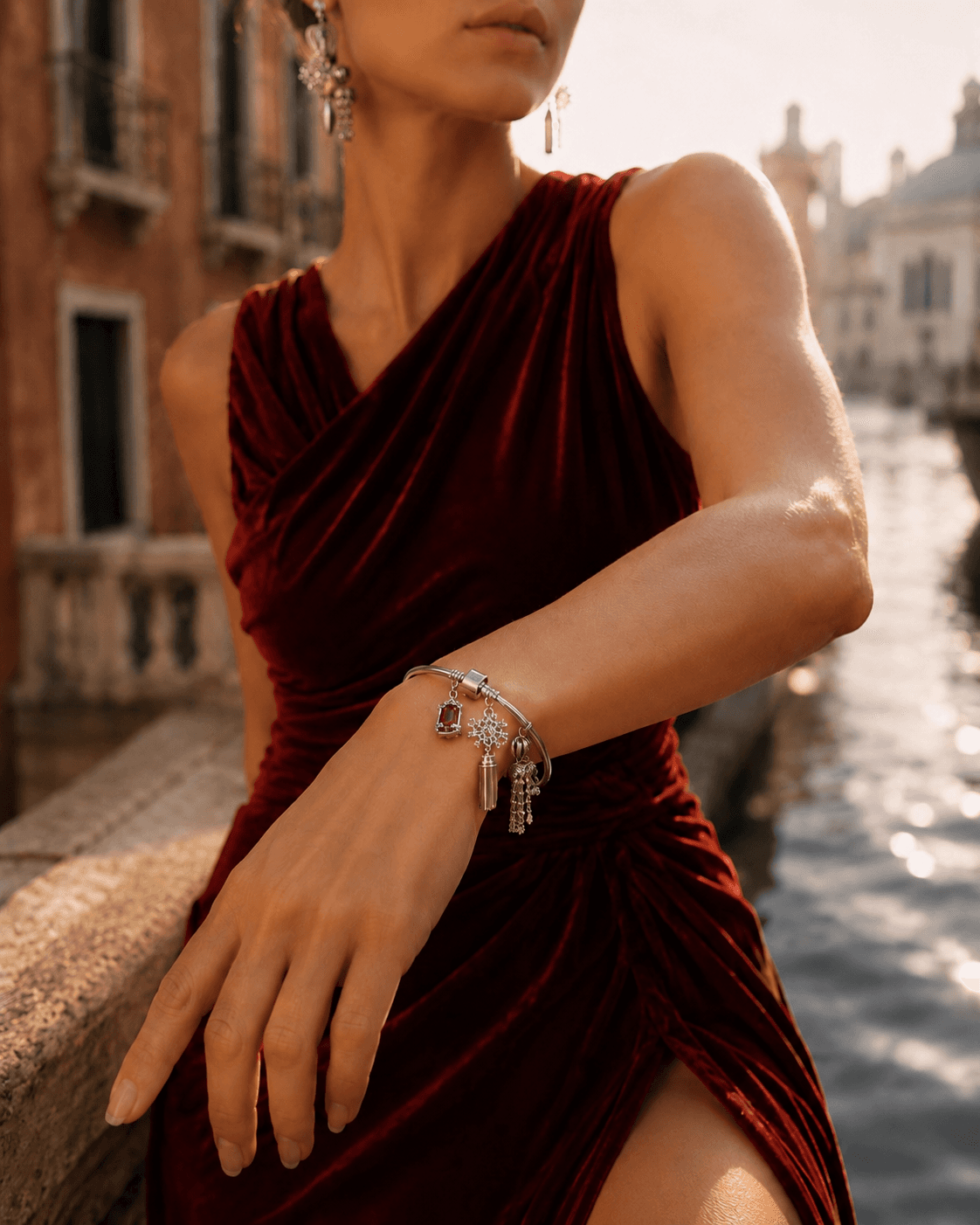 Sterling silver charm bracelet with rose-gold clasp accent styled with a red dress in Venice